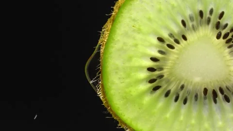 Creative layout of sliced kiwi and water. Splashes on black background. Vídeo Stock 251914385