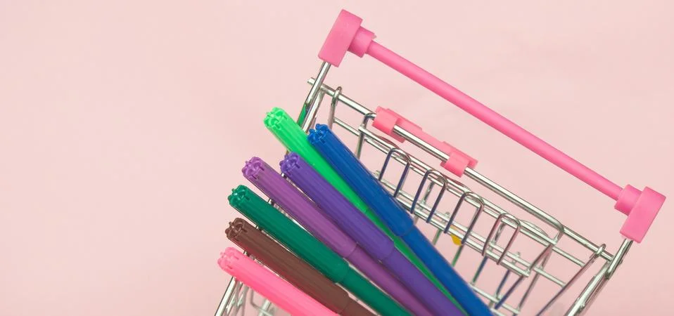 Creative learning and creativity concept with shopping cart with markers on pink Stock Photos
