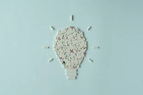 Creative light bulb shape made of white plastic blocks on pastel background Stock Photos