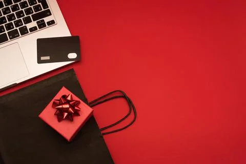Creative look, red gift box, laptop, credit card and black package on red Stock Photos