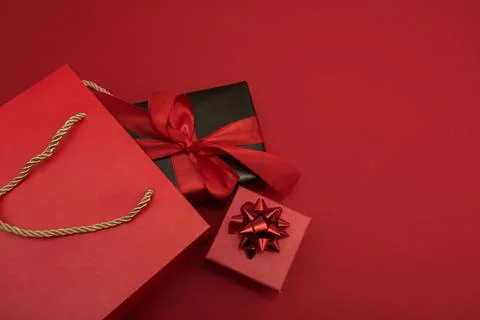 Creative look, two red and black gift boxes and a red shopping bag on a red Stock Photos