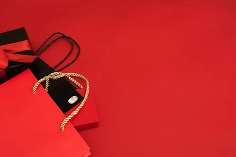 Creative look, two red and black gift boxes and a red shopping bag on a red Stock Photos