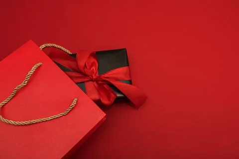 Creative look, two red and black gift boxes and a red shopping bag on a red Stock Photos