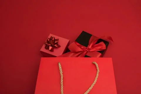 Creative look, two red and black gift boxes and a red shopping bag on a red Stock Photos