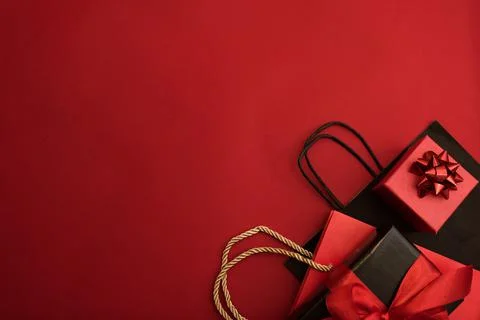 Creative look, two red and black gift boxes and a red shopping bag on a red Stock Photos