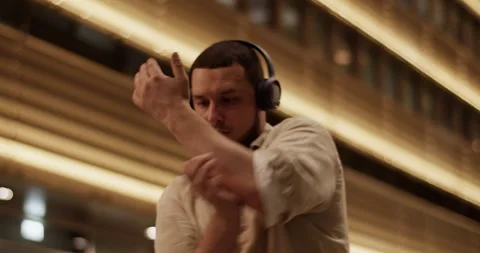 Creative male dancer looking around in night city Stock Footage 244475776