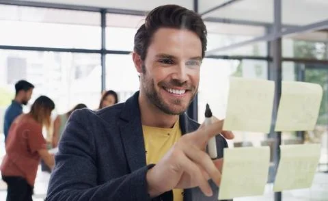 Creative, man and reading notes on glass wall for planning, strategy and ideas 写真素材