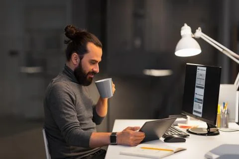 Creative man with computer working at night office 库存照片