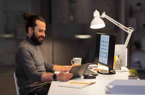 Creative man with computer working at night office Foto stock