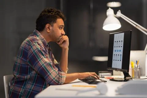 Creative man with computer working at night office Stock Photos