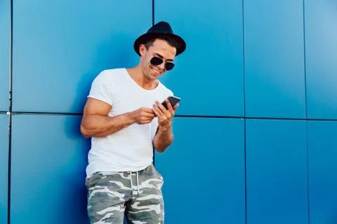 Creative man looking at smartphone screen, standing outdoors Stock Photos