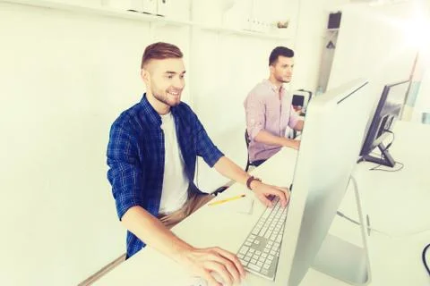Creative man or student with computer at office Stock Photos