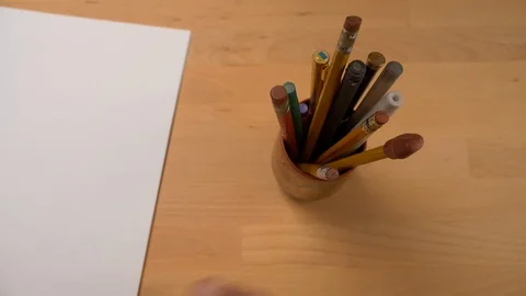 A creative man searching for a sharp pencil in a pencil holder Stock Footage 88638398