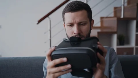 Creative man is sitting on coach and examining new digital technology device Stock Footage 105113276