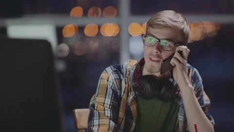 Creative man is working in late hours at office and talking on phone Stock Footage 87160911