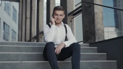 Creative manager talking with business partner on cellphone on the stairs Stock Footage 138836425
