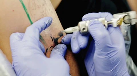 Creative master draws tattoo on the man's shoulder Stock Footage 61323625