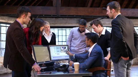 Creative media editor at work. Small team gathering to discuss a project in Vídeo Stock 32729222