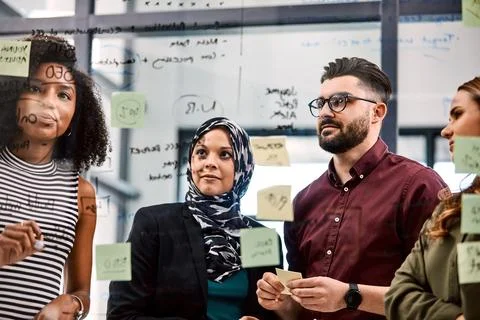 Creative, meeting and group with ideas in glass office, talk or sticky note.. Stock Photos