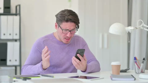 Creative Middle Aged Man Reacting to Loss on Smartphone Video stock 143567261