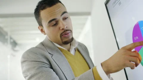 Creative millennial businessman talking about pie chart in meeting Stock Footage 67002266