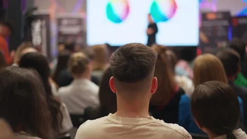 Creative minds gather for self-improvement talk, blurred presenter on stage Video stock 269970255