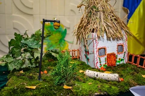 Creative miniature house display featuring straw roof and garden elements 스톡 사진