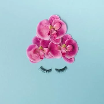 Creative minimal flat lay created with eye lashes and bright pink flowers on  Foto stock