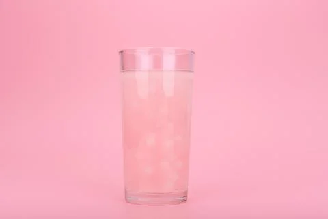 Creative minimal summer composition with pink drink against bright pink Stock Photos