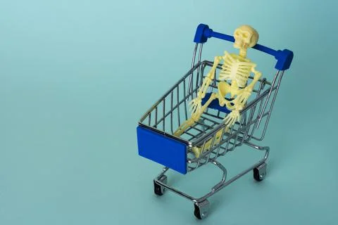 Creative minimalist composition, a skeleton riding on a supermarket cart, tur Foto stock