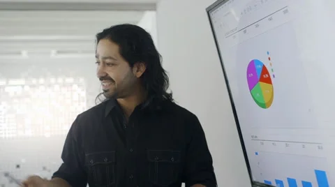 Creative mixed race businessman talking about pie chart in meeting Stock Footage 67004955