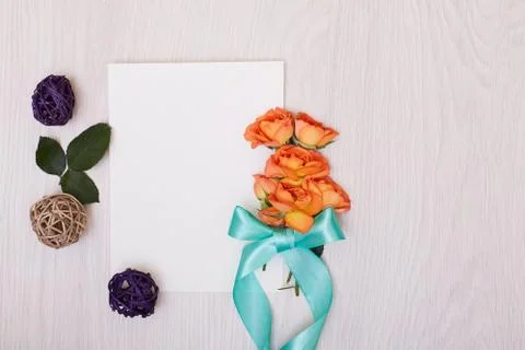 Creative mock up with a card and orang rose. Empty sheet of paper. Stock Photos