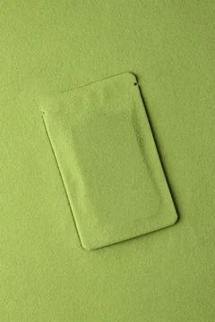 Creative mockup of a green pouch blending into vibrant matcha powder backgr.. Stock Photos