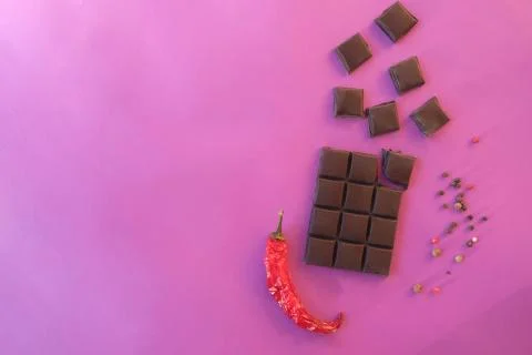 Creative mockup made of chocolate, red pepper on a pink background. Stock Photos