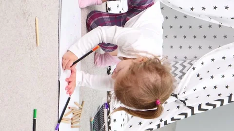 Creative moments of a child exploring art in a cozy play space at home 스톡 동영상 295355931