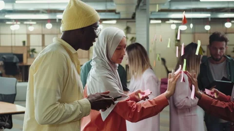 Creative multiethnic business team making notes on sticky notes near the Stock Footage 209184669
