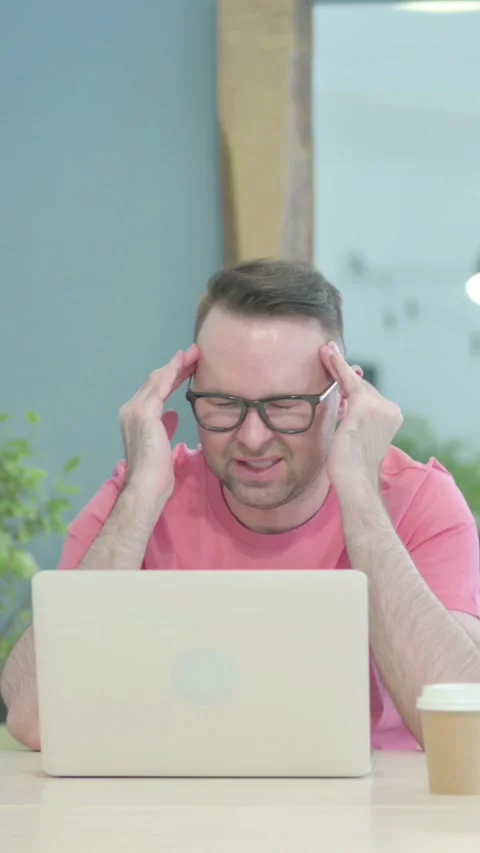 Creative Old Man having Headache while Working on Laptop, vertical video Video stock 329106188
