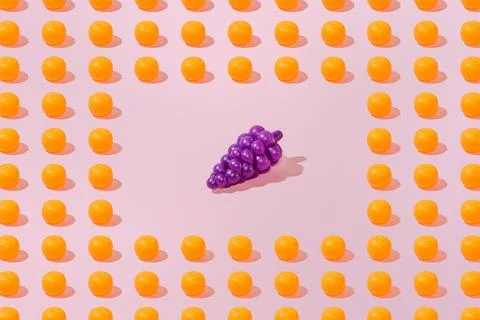 Creative orange and grape pattern flat lay on pastel pink background minimali Foto stock