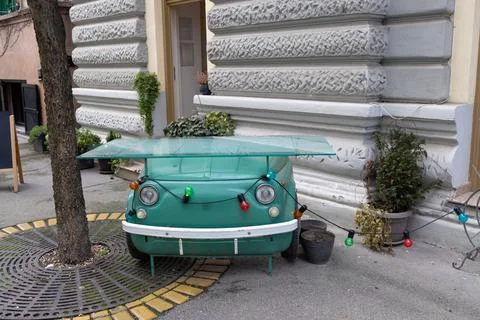 A creative outdoor table repurposed from the front of a vintage green car Foto stock