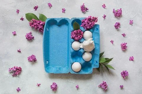 Creative pack of eggs with decorative lilac flowers. Easter concept. Stock Photos