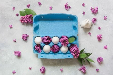 Creative pack of eggs with decorative lilac flowers. Easter concept. Stock Photos