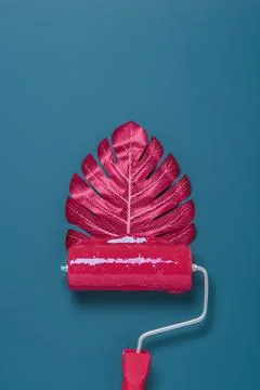 Creative paint roller with a vibrant pink leaf instead of foam shows fusion o Stock Photos