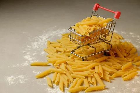 Creative pasta shopping experience with mini cart and floury backdrop Stock Photos