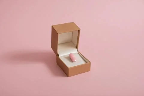 Creative pastel composition made of pink pill and engagement ring box. Minima Foto stock