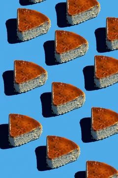Creative pattern of Basque cheesecake on blue background with hard shadow. .. Stock Photos