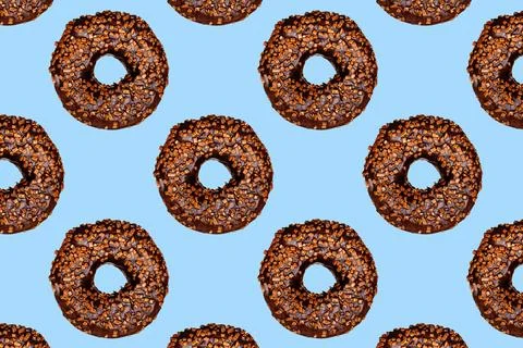 Creative pattern of chocolate donuts with holes on a blue background. Stock Photos