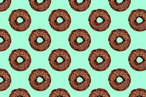 Creative pattern of chocolate donuts with holes on a mint background. Stock Photos