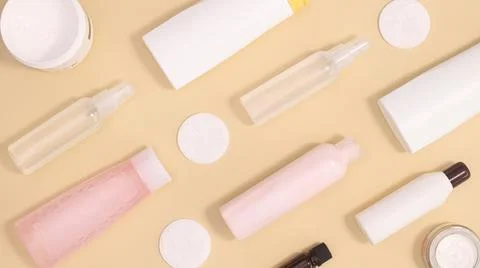 Creative pattern with cosmetics and skin care spa products on pastel beige ba Stock Photos