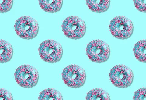 Creative pattern design of glazed donuts on light blue background Stock Photos
