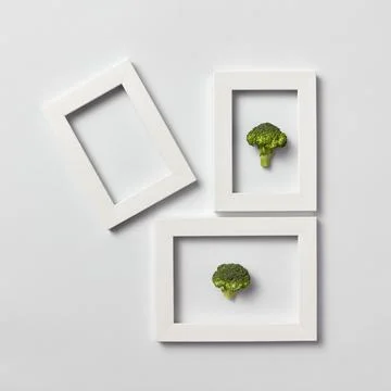 Creative pattern of frames with natural organic broccoli on a light backgroun Stock Photos